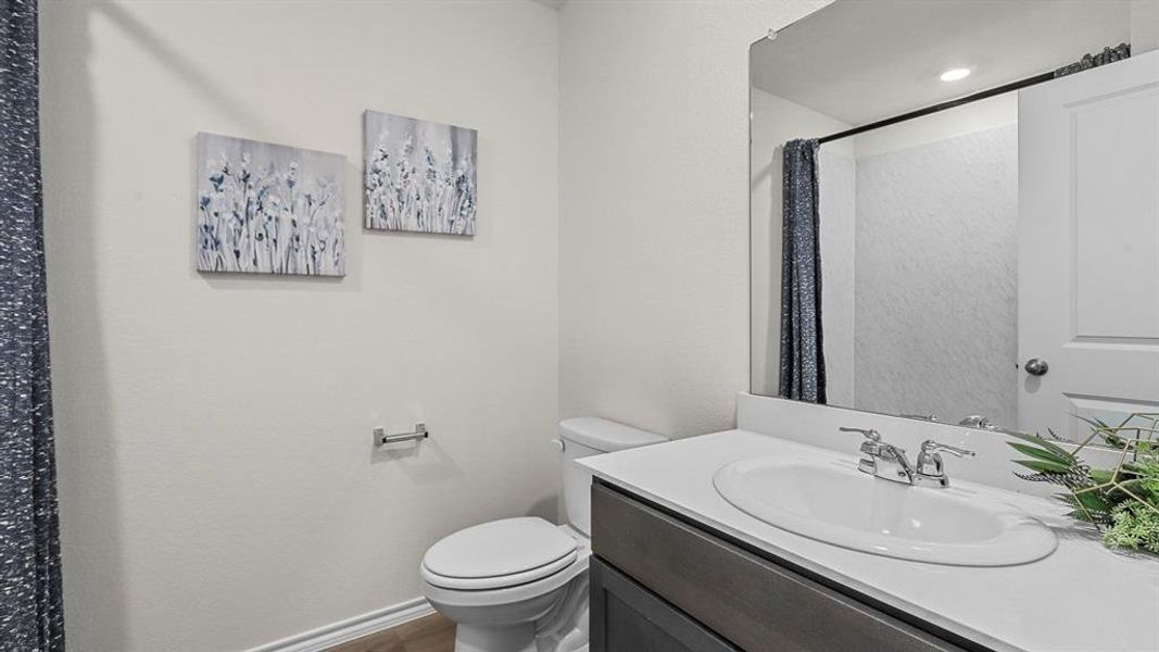 Full bath featuring vanity, a shower with shower curtain, and dark wood-style floors