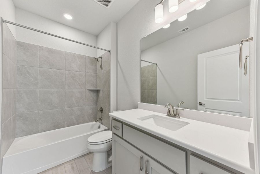 Full bathroom featuring shower / bath combination, vanity, light wood-style flooring, and recessed lighting Full bathroom featuring shower / bath combination, vanity, light wood-style flooring, and recessed lighting