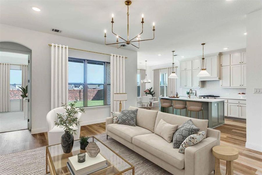 Living room featuring recessed lighting, a chandelier, light wood-style floors, and healthy amount of natural light Living room featuring recessed lighting, a chandelier, light wood-style floors, and healthy amount of natural light
