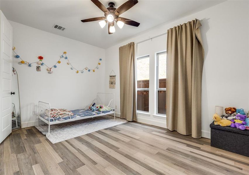 Bedroom with light wood finished floors and ceiling fan