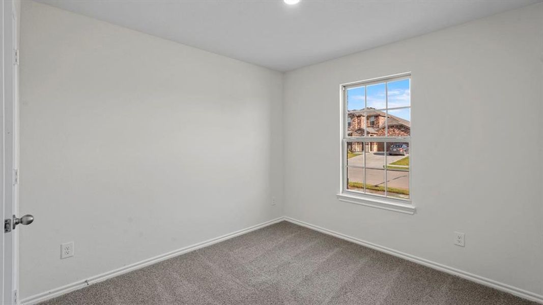 Carpeted spare room featuring baseboards