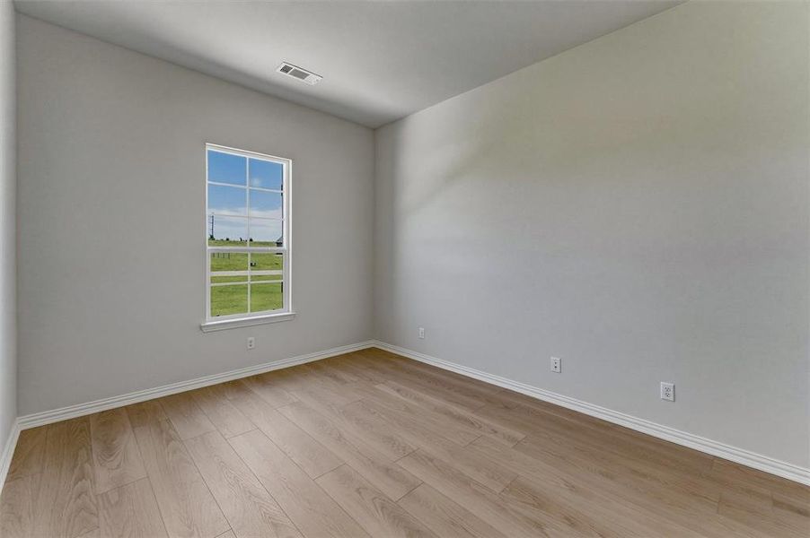 Bright room featuring wood-finish flooring and a window with a white frame