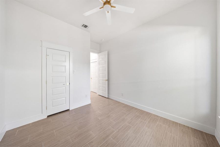 Empty room featuring wood finish floors and a ceiling fan