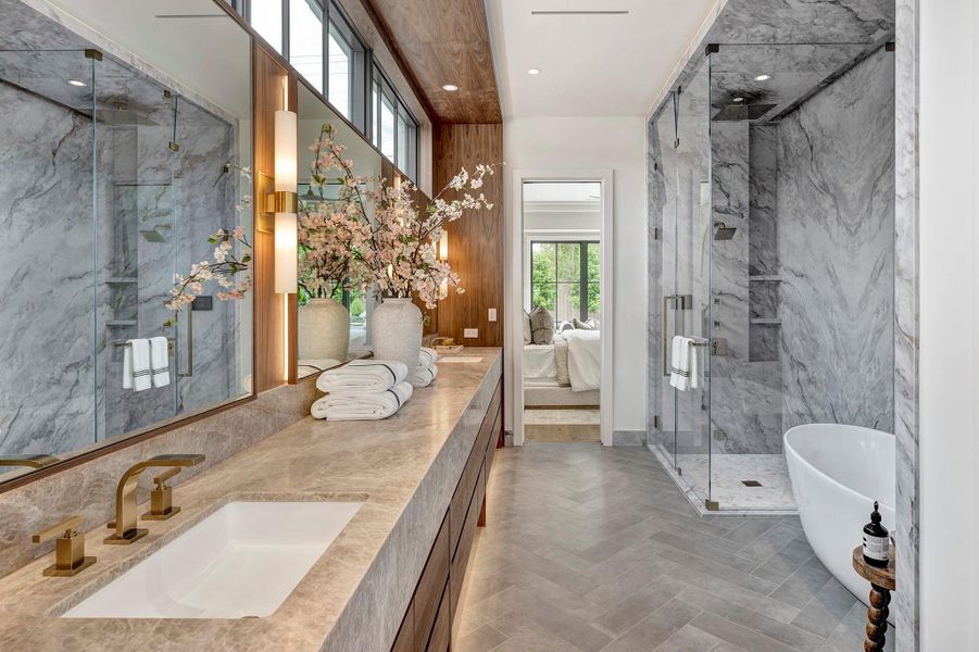 Primary bathroom features a steam shower and stand alone tub and warm wood accents..