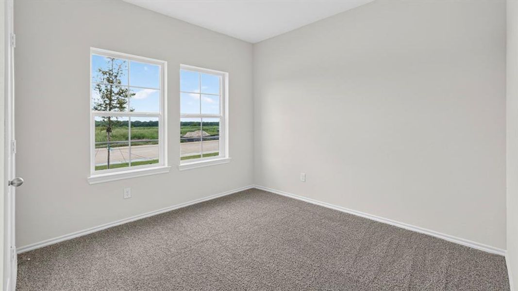 Spacious room featuring two large windows, light gray wall paint, white trim, and gray carpeting Spacious room featuring two large windows, light gray wall paint, white trim, and gray carpeting