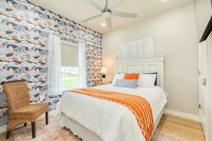 Inviting guest bedroom features coastal-inspired finishes, a stylish accent wall, and abundant natural light for a bright, comfortable retreat.