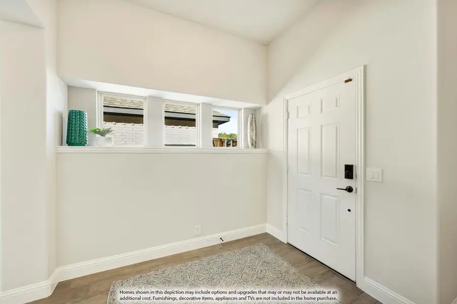 Entryway with white six-panel front door, built-in shelf with windows, and wood-look floors