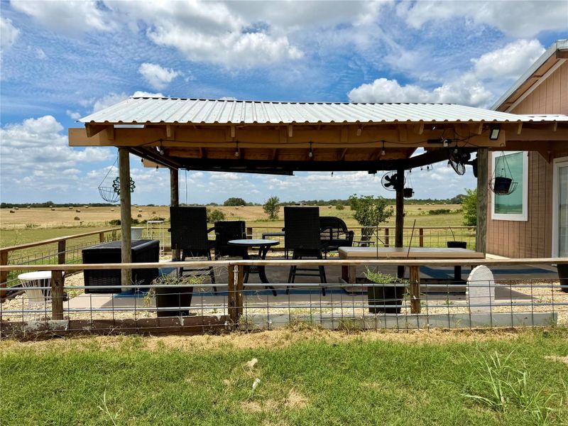 A spacious covered patio overlooks sweeping rural landscapes, perfect for tranquil outdoor living.