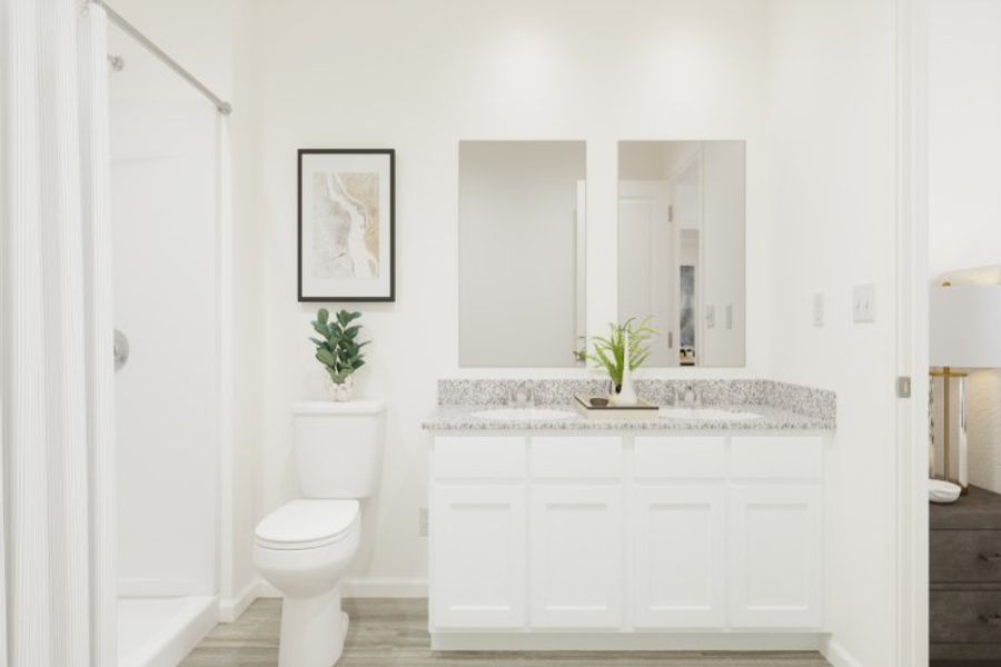 A bathroom with a sink toilet and a plant.