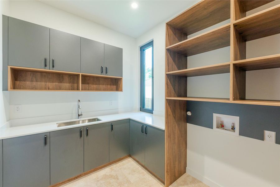 A dedicated laundry space offers practical storage and a functional sink for household tasks.