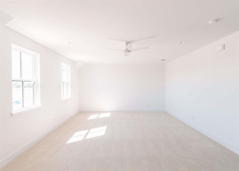 Unfurnished room featuring ceiling fan and light colored carpet