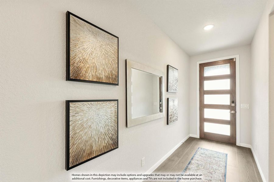 Entryway hallway with wood-look floors, modern front door with glass panels, and decorative wall art and mirror Entryway hallway with wood-look floors, modern front door with glass panels, and decorative wall art and mirror