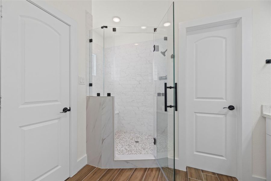 This luxurious primary bathroom shower features a built-in bench for added comfort and convenience. Enclosed by a sleek glass door, the space combines functionality with modern elegance. This luxurious primary bathroom shower features a built-in bench for added comfort and convenience. Enclosed by a sleek glass door, the space combines functionality with modern elegance.