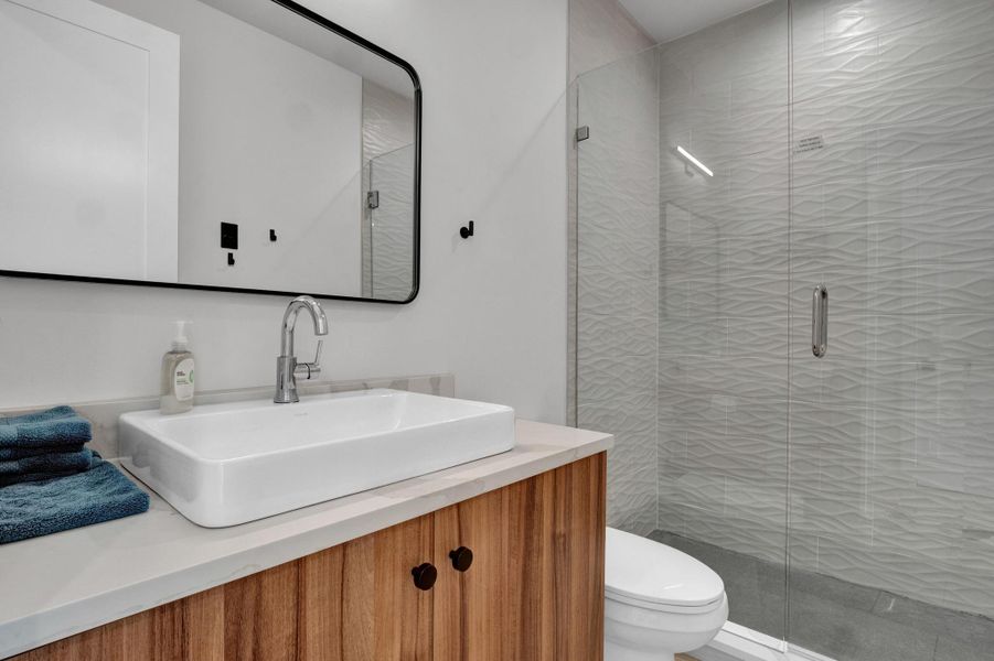 Bathroom featuring a shower stall and vanity