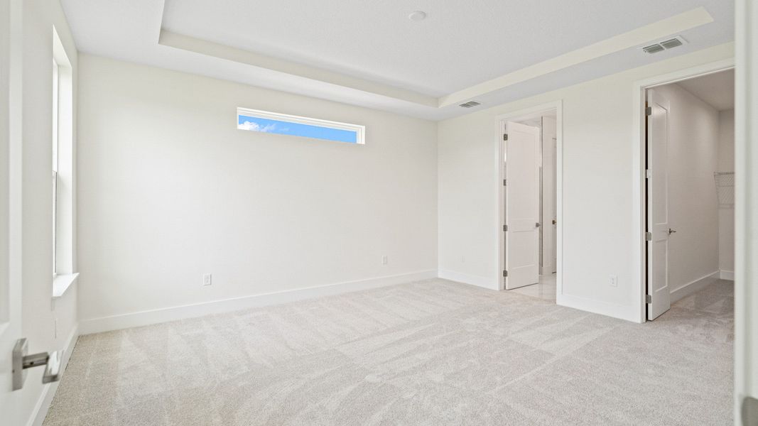 The Sweetgum Spacious and Bright first floor primary suite with large walk-in closet at Trailside in Mount Dora by DRB Homes