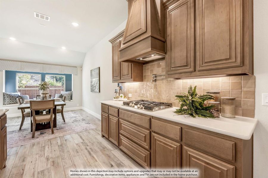 Kitchen with brown wood cabinets, gas cooktop, tile backsplash, and dining area visible in background Kitchen with brown wood cabinets, gas cooktop, tile backsplash, and dining area visible in background