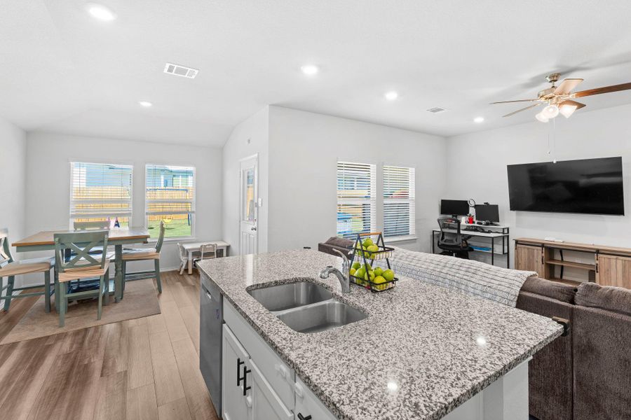 A versatile open-concept living space features a kitchen island, dining area, and a comfortable lounging zone. A versatile open-concept living space features a kitchen island, dining area, and a comfortable lounging zone.