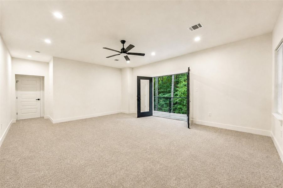 The Primary bedroom has French doors opening to a private balcony with serene outdoor views, perfect for relaxation.