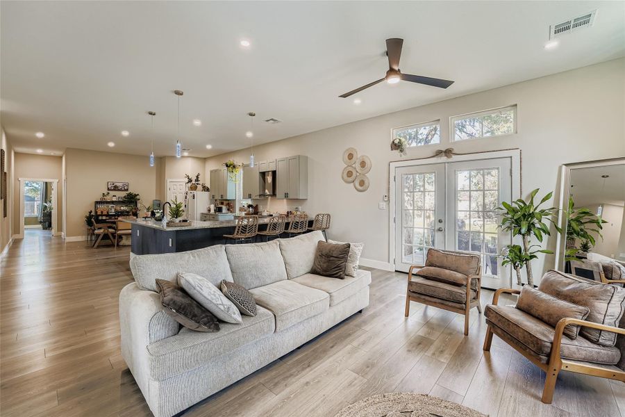 Living room with recessed lighting, french doors, light wood finished floors, and ceiling fan Living room with recessed lighting, french doors, light wood finished floors, and ceiling fan