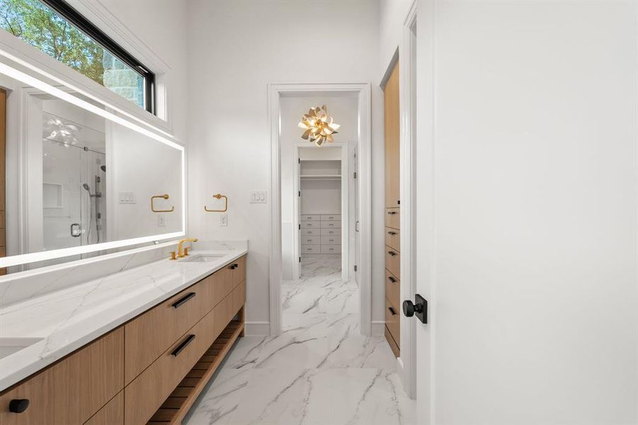 Mast Bathroom featuring double vanity, a shower stall, light marble finish floors, and a spacious closet Mast Bathroom featuring double vanity, a shower stall, light marble finish floors, and a spacious closet
