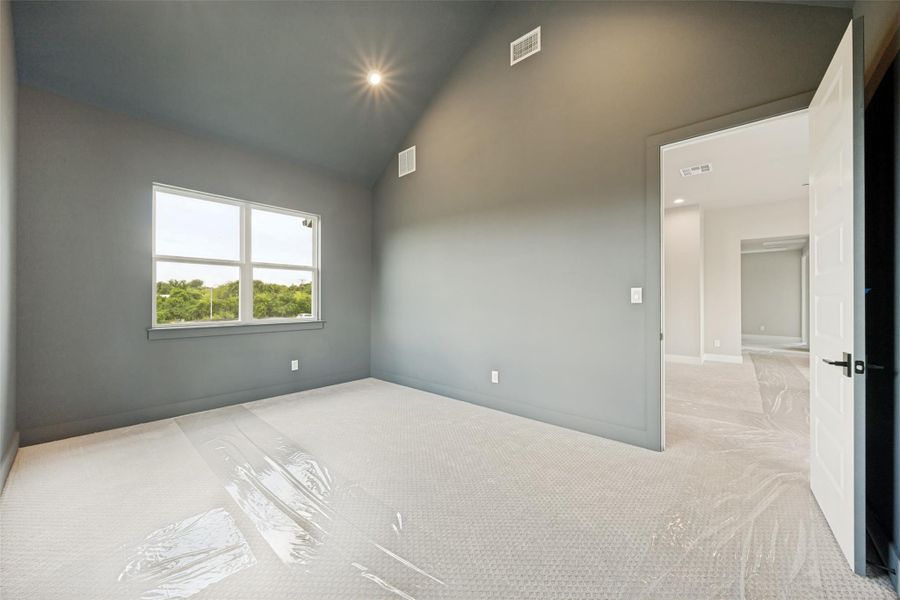 A well-lit bonus room features vaulted ceilings and ample natural illumination from a large window. A well-lit bonus room features vaulted ceilings and ample natural illumination from a large window.