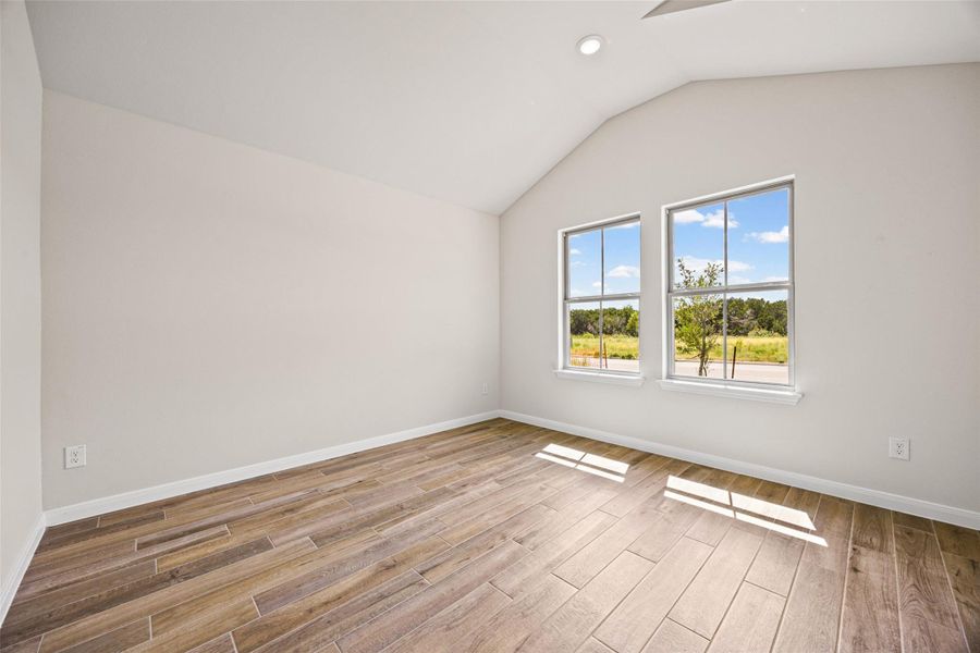 Formal dining or formal living room with angled ceilings and wood-look tile flooring frame views of the scenic outdoors. Formal dining or formal living room with angled ceilings and wood-look tile flooring frame views of the scenic outdoors.