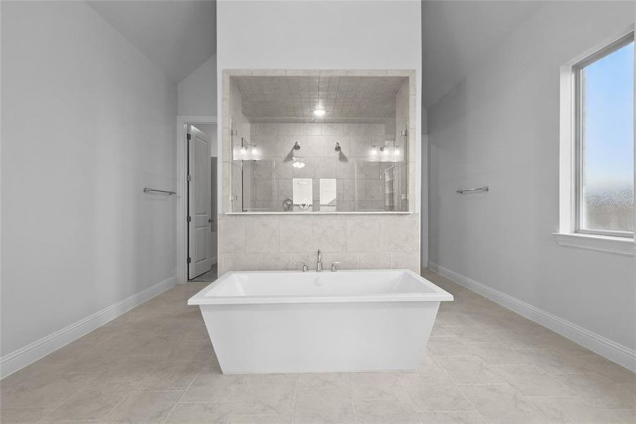 Bathroom featuring plenty of natural light, a freestanding bath, tile patterned flooring, and tiled shower Bathroom featuring plenty of natural light, a freestanding bath, tile patterned flooring, and tiled shower