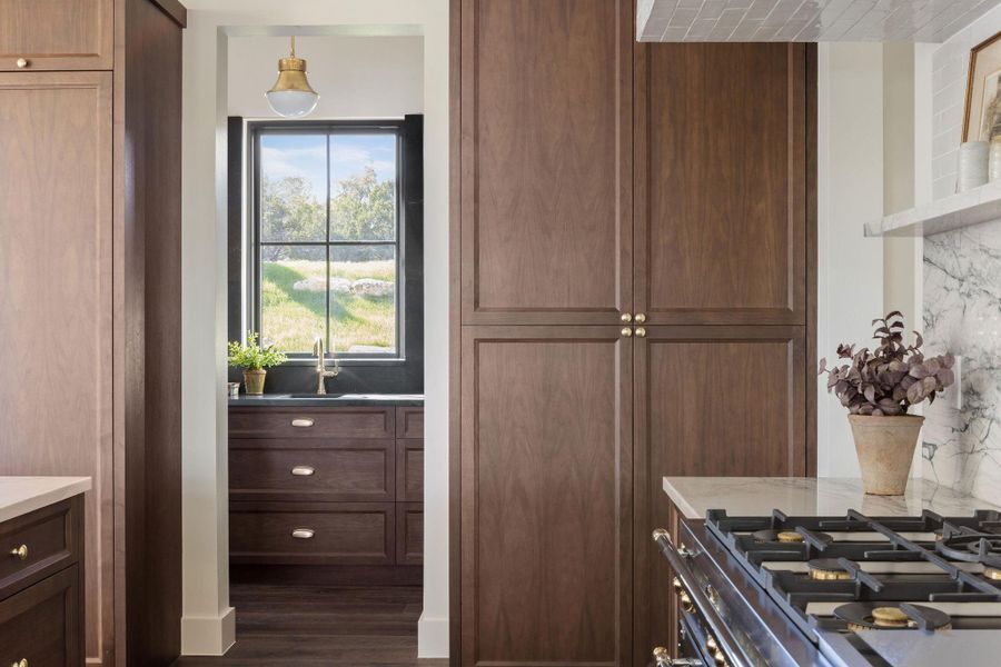 Gourmet luxury kitchen with Fantasy Luxe Quartzite Countertops, Bertazzoni Heritage Range, and Walnut Cabinets