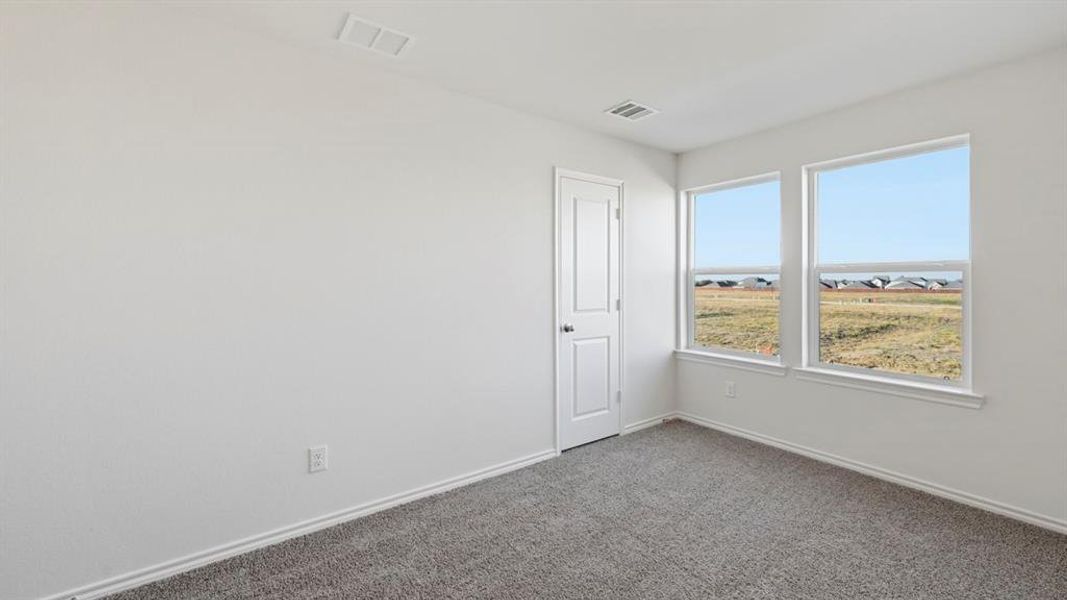 Carpeted spare room featuring baseboards Carpeted spare room featuring baseboards