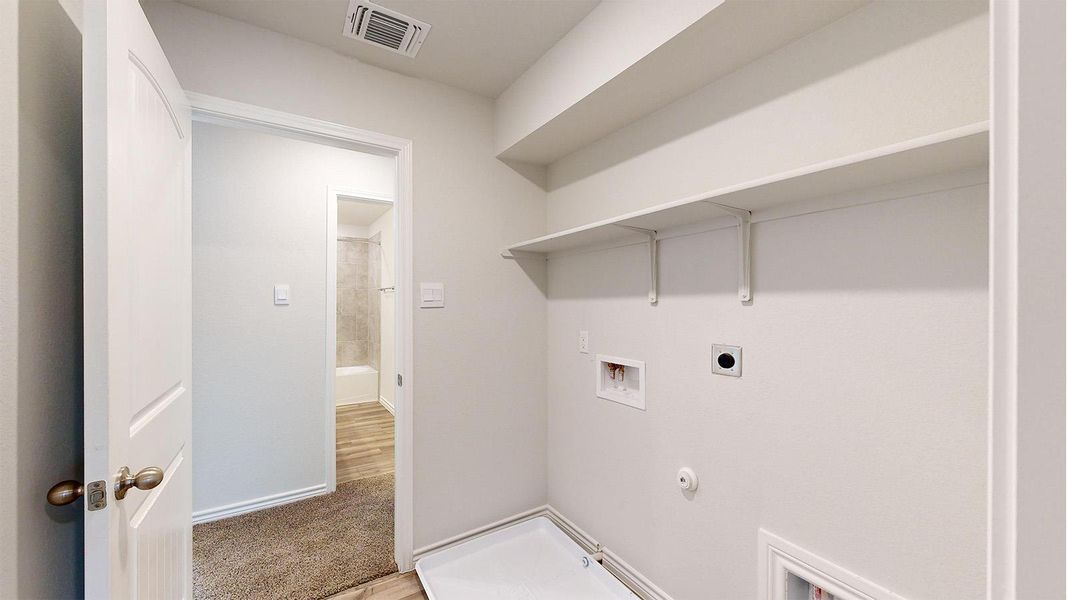 Dedicated laundry area featuring built-in shelving, plumbing rough-ins, and electrical outlets Dedicated laundry area featuring built-in shelving, plumbing rough-ins, and electrical outlets