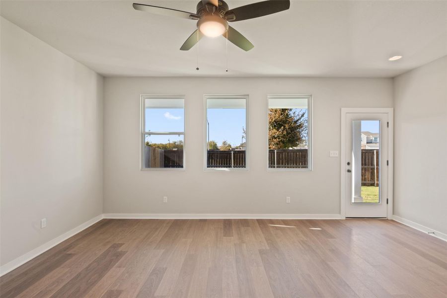 Empty room with light wood-style floors and ceiling fan