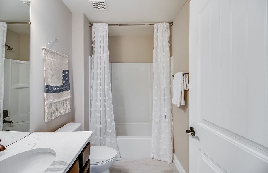 Secondary Bathroom with a tub/shower combo and til Secondary Bathroom with a tub/shower combo and til