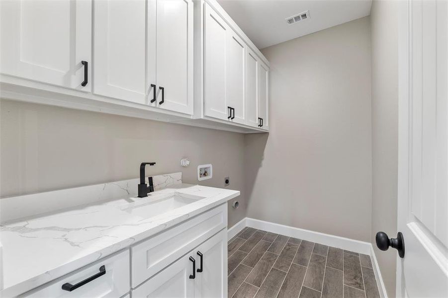 Laundry room with sink, hookup for a washing machine, cabinets, and hookup for an electric dryer