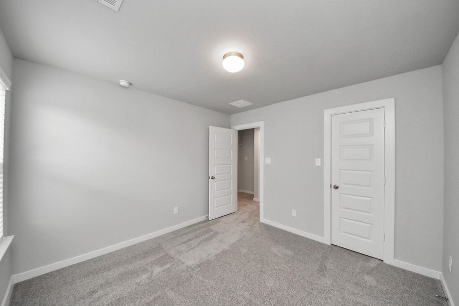 Generously sized secondary bedrooms featuring spacious closets, soft and inviting carpeting underfoot, large windows allowing plenty of natural light, and the added touch of privacy blinds for your personal retreat.