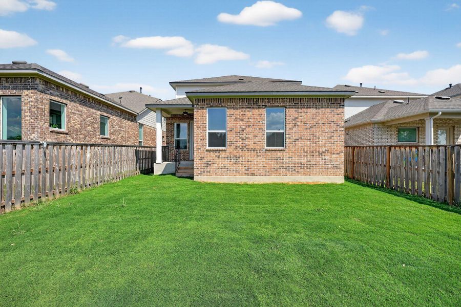 Rear view of house with brick siding, a fenced backyard, a patio, and roof with shingles Rear view of house with brick siding, a fenced backyard, a patio, and roof with shingles