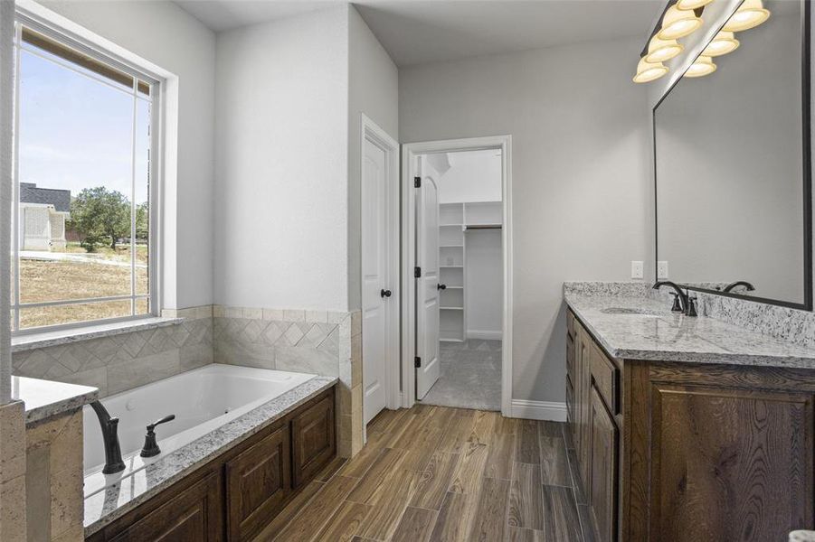 Bathroom featuring a tub, vanity, and hardwood / wood-style floors