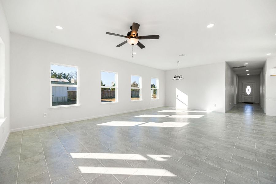 Bright and spacious open-concept living and dining area with large windows and modern tile flooring, perfect for entertaining and relaxation. Bright and spacious open-concept living and dining area with large windows and modern tile flooring, perfect for entertaining and relaxation.