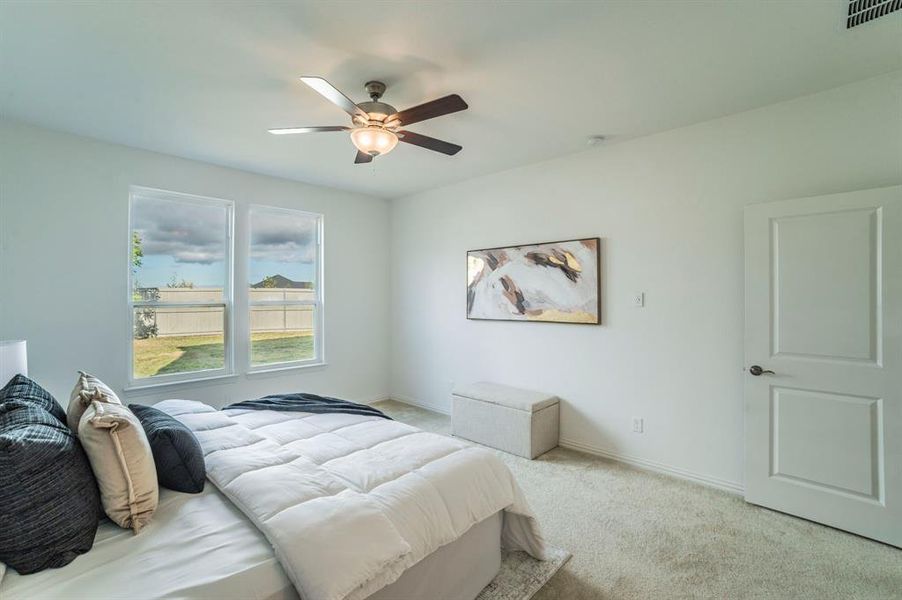 Carpeted bedroom with baseboards and ceiling fan Carpeted bedroom with baseboards and ceiling fan