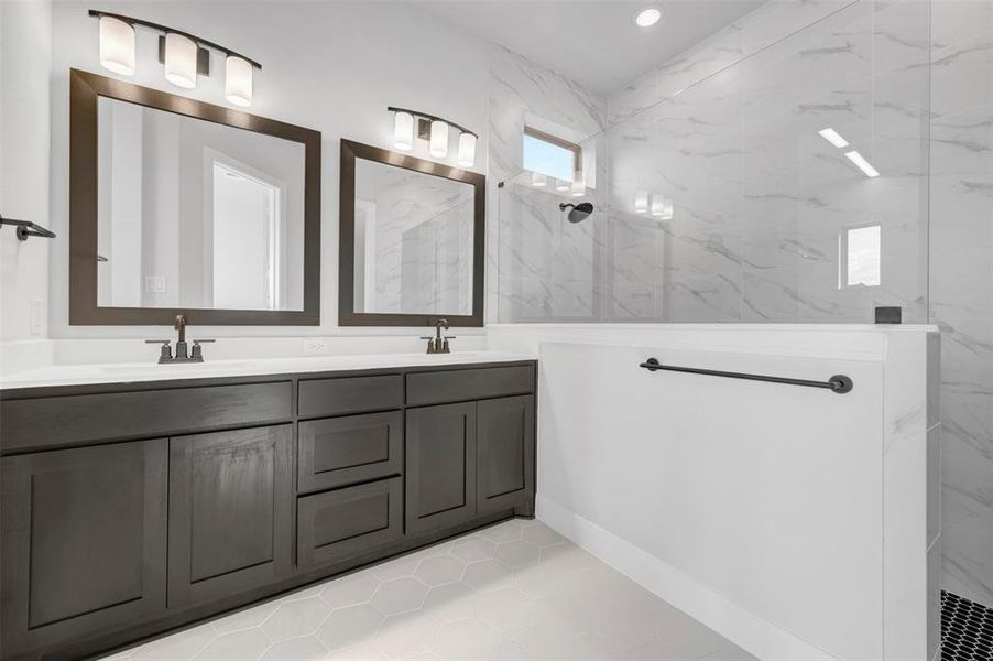 Full bathroom featuring double vanity, a marble finish shower, and light tile patterned floors Full bathroom featuring double vanity, a marble finish shower, and light tile patterned floors
