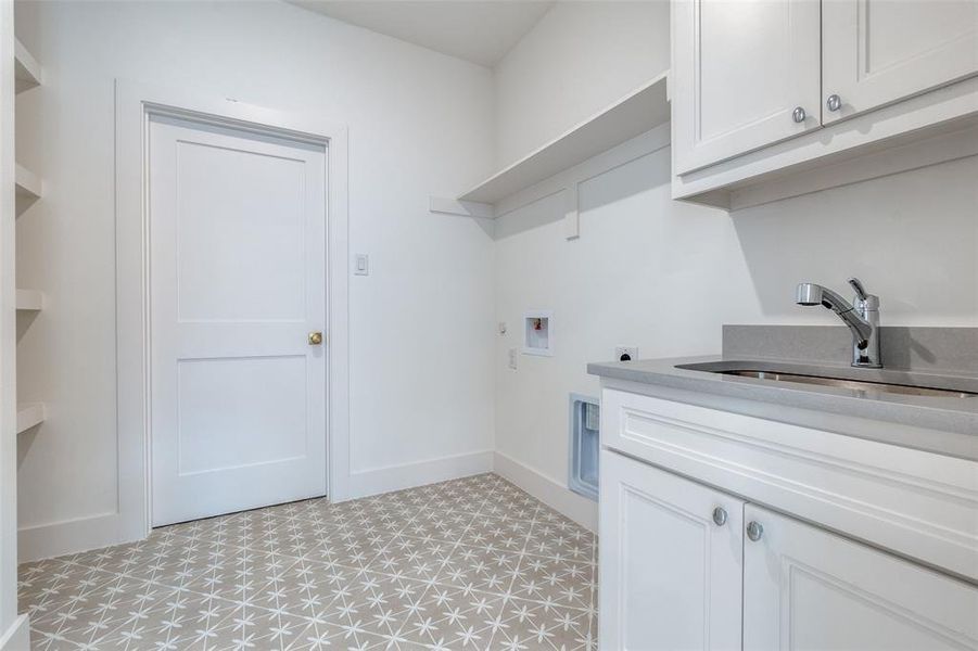 Clothes washing area with hookup for a washing machine, sink, hookup for an electric dryer, and cabinets