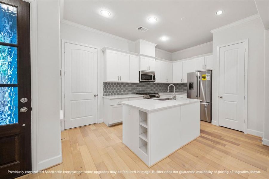 The heart of the home. Anchored by an island with a sink and ample pantry storage, this kitchen is where memories are made.