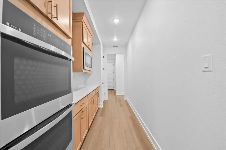 Corridor featuring light wood-style floors and recessed lighting Corridor featuring light wood-style floors and recessed lighting