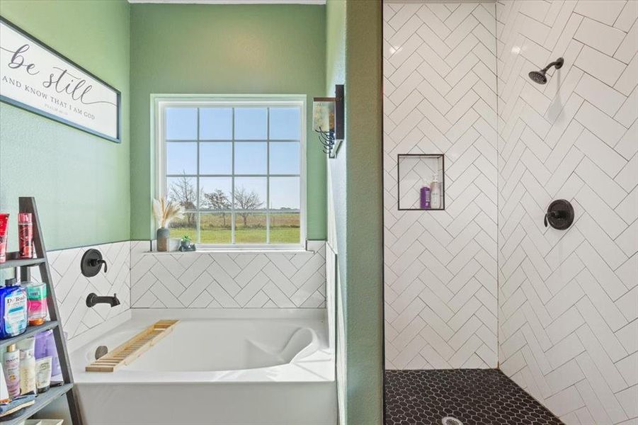 Bathroom featuring a garden tub, a shower stall, and tile walls