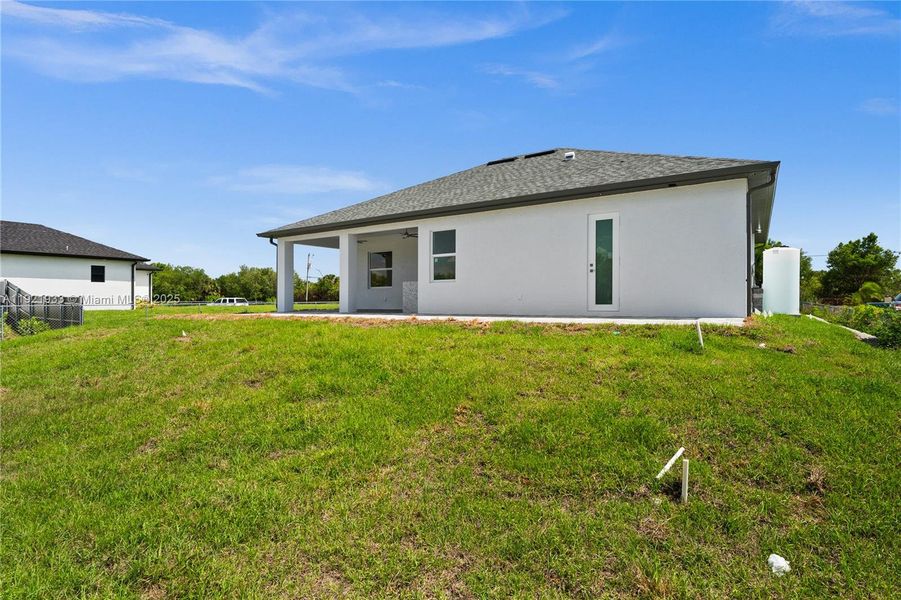 Back of house with a patio, stucco siding, ashingled roof, and ceiling fan Back of house with a patio, stucco siding, ashingled roof, and ceiling fan