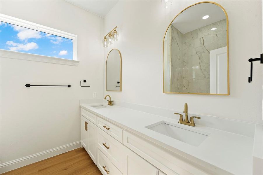 Full bathroom featuring double vanity and light wood-style floors