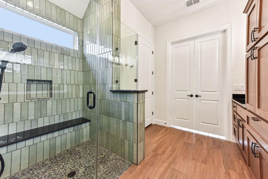 Full bathroom with a stall shower, light wood-style floors, and vanity