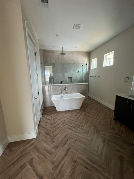 Bathroom featuring parquet flooring, vanity, and independent shower and bath