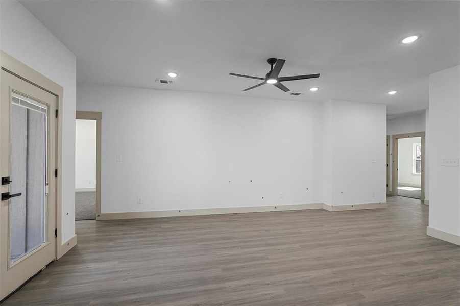Spare room with a ceiling fan, wood finished floors, visible vents, baseboards, and recessed lighting