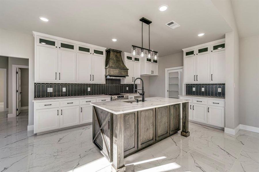 Kitchen featuring custom exhaust hood, recessed lighting, visible vents, and marble finish floor