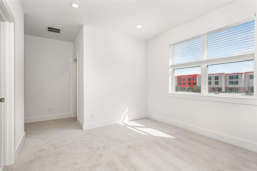 Unfurnished bedroom with light carpet and recessed lighting